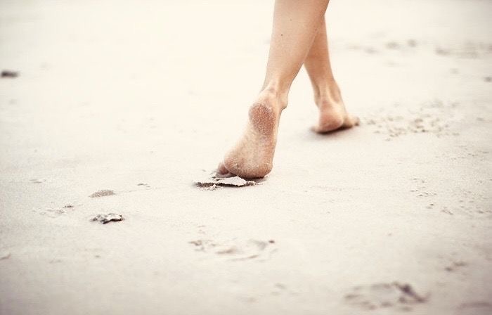 caminar descalzo en la arena de la playa
